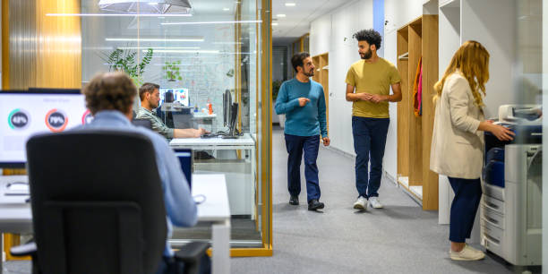 istock Diverse Team Engages in Casual Discussion in Office Corridor 2158643900