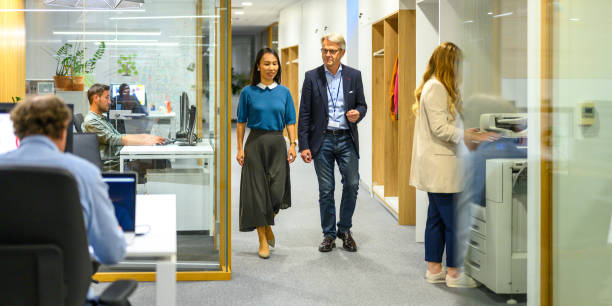 istock Diverse Professionals Walking in Modern Office Hallway 2158643907