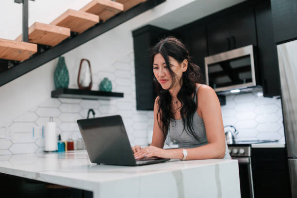 istock Woman Online With Laptop At Home In Kitchen 2158649505