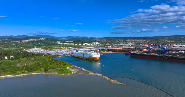 istock AERIAL: White and yellow freight ship loading cars from Koper port parking lot. 2158649886