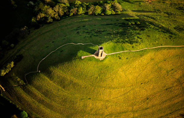 St Michael's Tower built  in the 14th century on top of Glastonbury Tor in Somerset eclipses the Full Moon. People (in silhouette) gather to watch the moon rise over the Glastonbury Levels.Glastonbury in Somerset, England is often identified with the legendary island of Avalon, which is central to Arthurian legend800mm lens from half a mile distance to give this perspective, no image manipulation