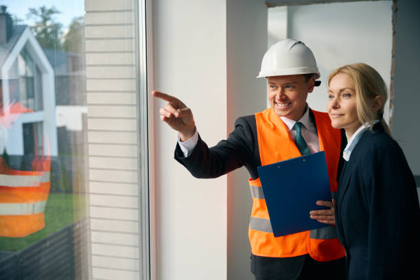 istock Smiling engineer and businesswoman standing and looking out window 2158653616