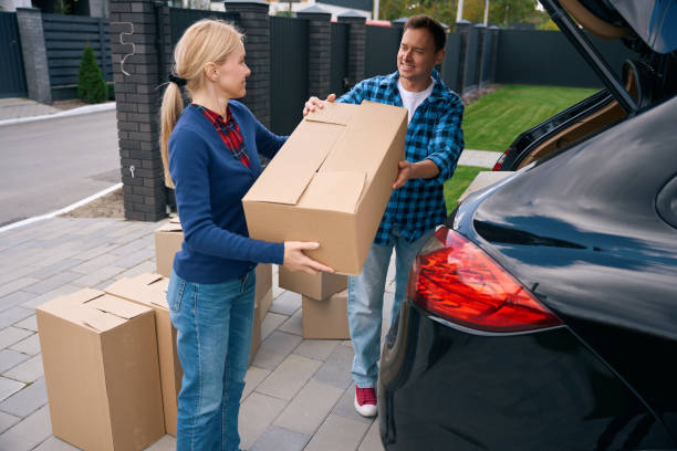 istock Lady standing and helping man to load boxes in car 2158653712