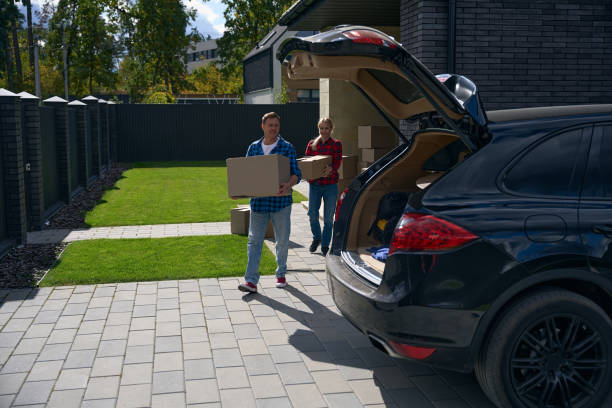 istock Cheerful couple carrying boxes to car during house move 2158653737
