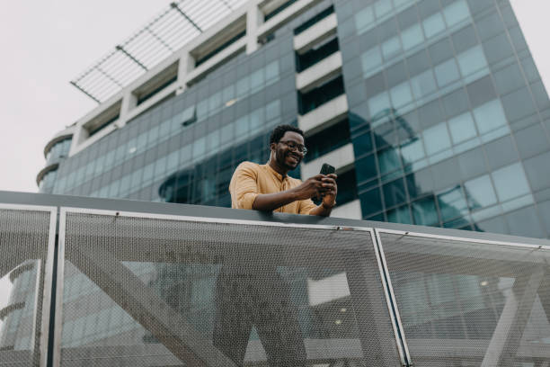 istock Businessman using phone on bridge near modern building 2158655656