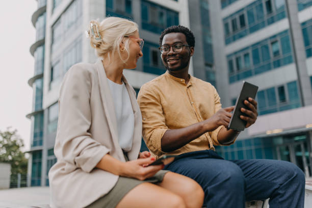 istock Colleagues sharing ideas on a tablet outdoors. 2158655868