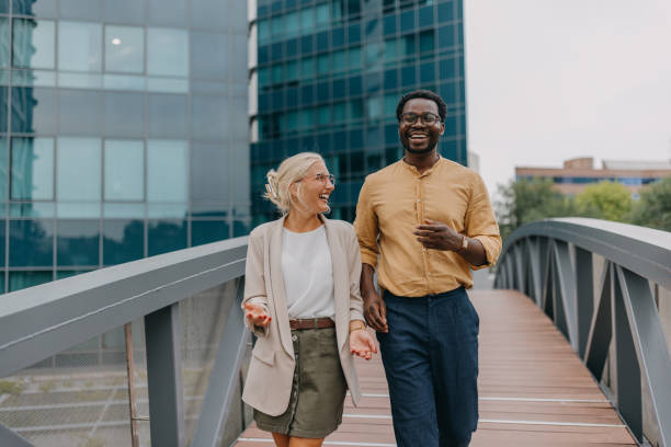 istock Happy man and woman talking while walking on bridge. 2158655899