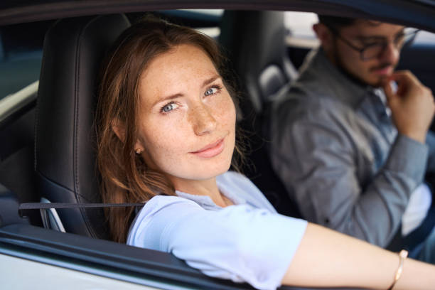 istock Woman looking at camera from car window while riding with her boyfriend 2158659521