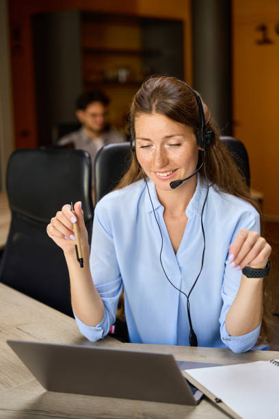 istock Young smiling woman call center operator watching on laptop work at desk 2158659866