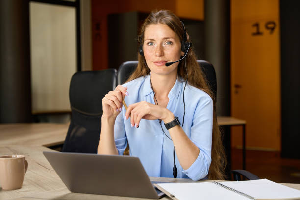 istock Young serious female call center operator looking at camera in coworking office 2158659870