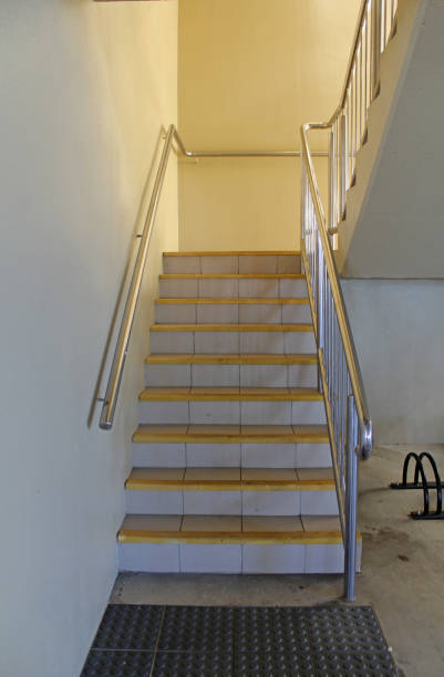 istock Indoor staircase with steps leading upwards and metal handrails on both sides 2158666715