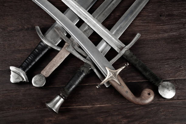 istock Swords and sabre on wooden background. 2158666718