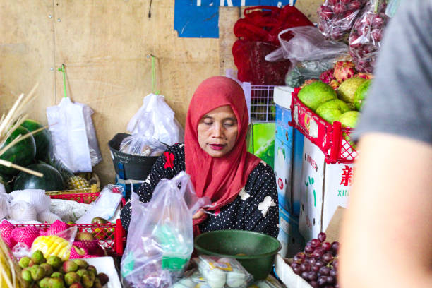 Indonesia, Solo - June 22,2024 : fruit and vegetable kiosk sellers are serving buyers