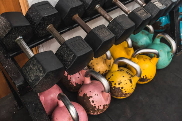 istock Old hex dumbbells on a rack with large color coded kettlebells below. At a hardcore, old school gym. 2158667262