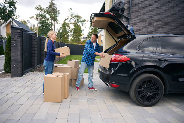 istock Happy couple standing near car and loading boxes in it 2158667690