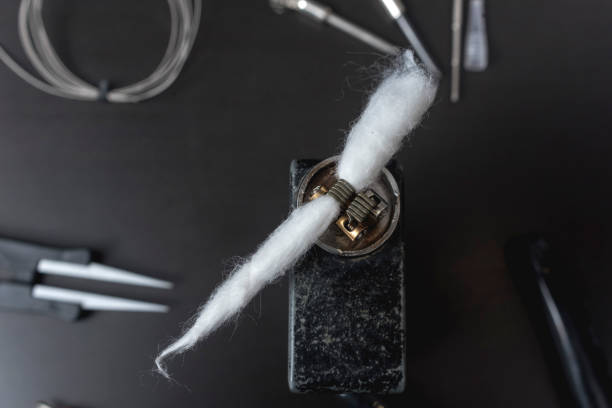 istock Cotton inserted into the coil of the atomizer. Rebuilding a box mod vape or RDA atomizer. 2158668182