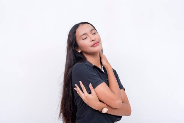 istock A young asian woman embracing herself while feeling blissful. Self-love concept. Isolated on a white backdrop. 2158672757