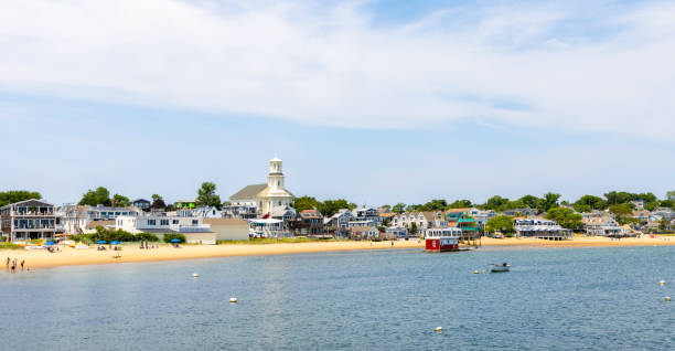 Houses and a church overlook the beach and harbor in downtown Provincetown, Massachusetts.