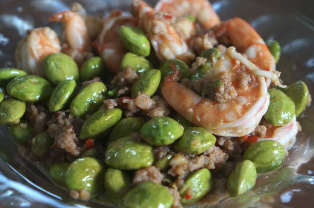 Fresh salad with shrimps and edamame soybeans in bowl on a white table.