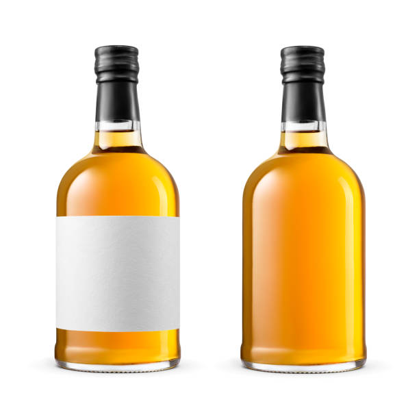 Two bottles of amber color alcohol, whisky, brandy, cognac isolated on white background. Two bottles of amber color alcohol, whisky, brandy, cognac isolated on white background. Clean paper label for your design. amber black photography stock pictures, royalty-free photos & images