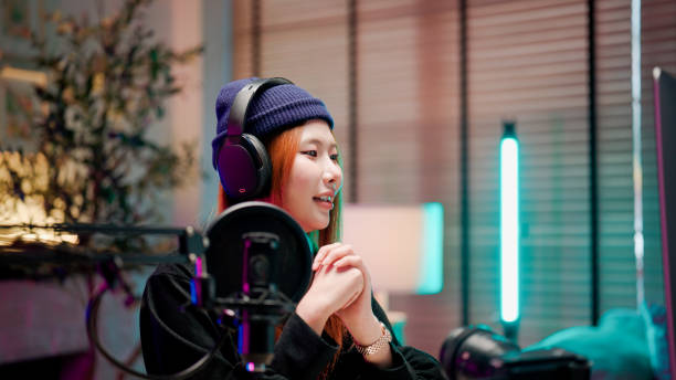istock Young Asian woman listening to her audience during a conversation in her podcast session. 2158679708