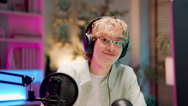 istock Young Asian man having conversation with her listener while holding a podcast session. 2158679722