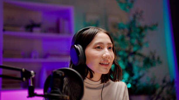 istock Young Asian woman having conversation with her listener while holding a podcast session. 2158679742