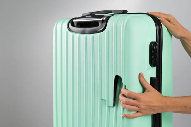 istock A woman demonstrates a broken suitcase on a white background. Damaged baggage during the flight. 2158679977