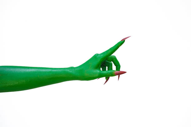 A green monster hand with long nails, isolated against a dark background, evokes horror and fear. Perfect for Halloween, this spooky image captures the essence of evil and the undead.