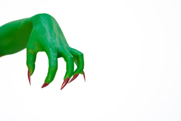 A green monster hand with long nails, isolated against a dark background, evokes horror and fear. Perfect for Halloween, this spooky image captures the essence of evil and the undead.