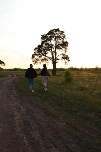istock A guy and a girl are running along a rural road. 2158686884