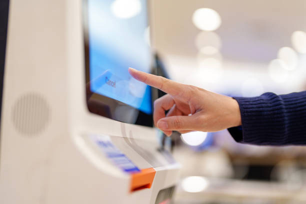 cropped shot of a woman making a payment using the touchscreen on a self-service kiosk in a grocery store. - autoservicio fotografías e imágenes de stock