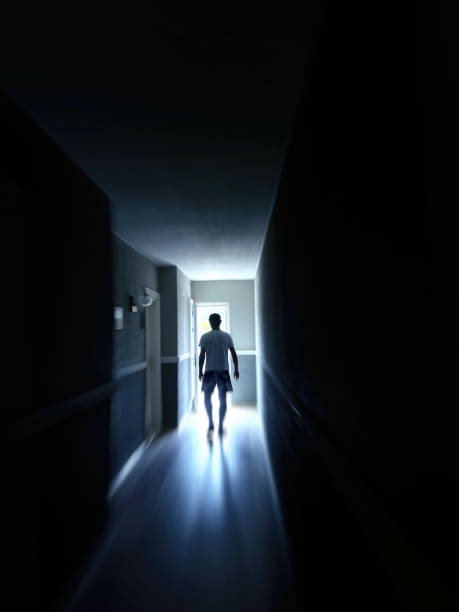 istock Single man walking at dark narrow corridor in to glowing light 2158688640