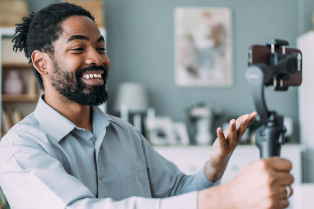 istock Young male content creator using smartphone to record vlog at home. 2158691806