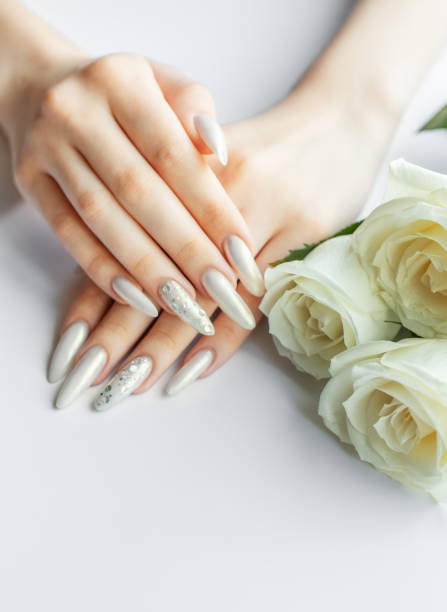 istock Female Hands on a white background with beautiful pearl manicure 2158693328