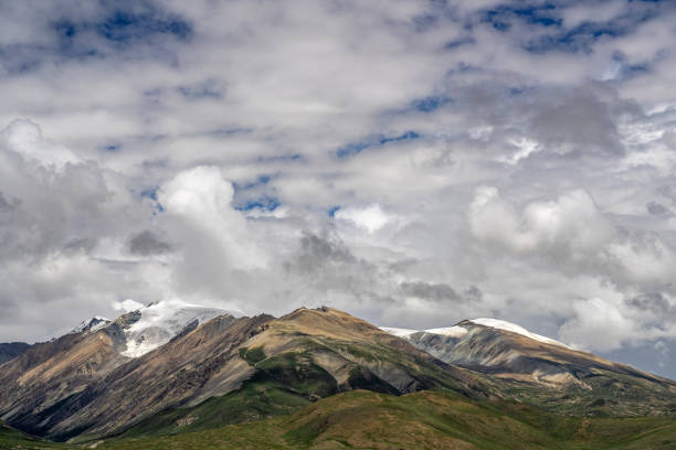Plateau snow-capped mountains and meadows in cloudy weather