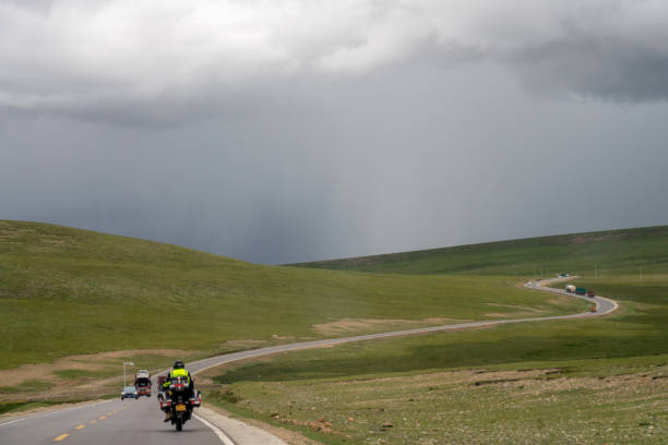 Highland meadows, mountains and roads in cloudy weather