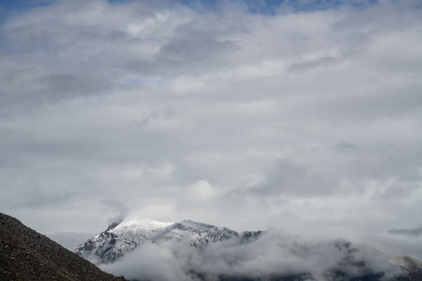 Barren mountains and snow-capped mountains on a cloudy day