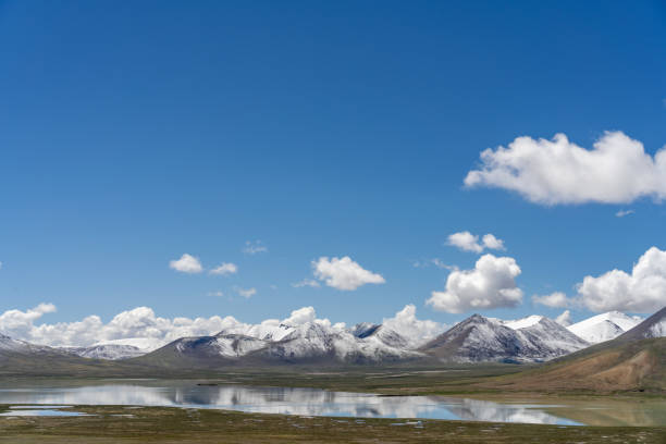 istock Plateau meadow and lake under blue sky and white clouds 2158698073