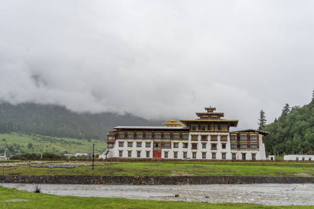 Paro, Bhutan: Rinpung Dzong / Paro Dzong watchtower ('utse'), with high inward sloping walls - large Buddhist monastery and fortress - triple  'nyimchu rabsel' open balcony, consists of a timber\nframe structure with multiple windows and panels that cantilevers from the wall - the red band around the external walls marks the structure as a sacred religious place, it is called a Keymar - Tentative List for UNESCO inclusion.