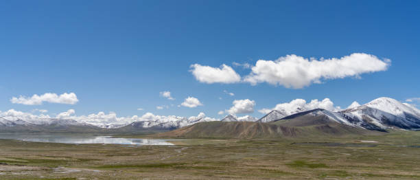 istock Plateau meadow and lake under blue sky and white clouds 2158699132