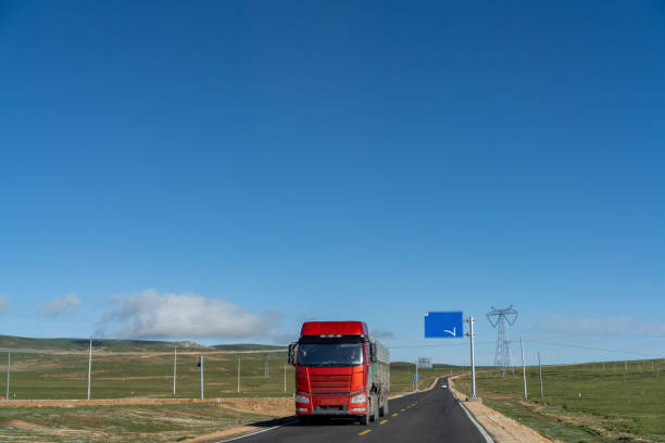 Meadow and road on the plateau under blue sky and white clouds