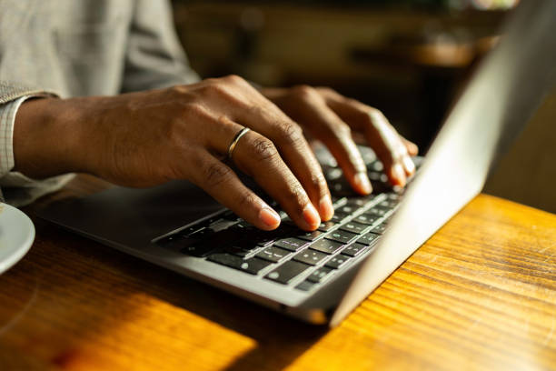 istock A detailed shot of hands typing on a laptop keyboard, captured in a warmly lit, cozy workspace. Ideal image for themes related to remote work, technology, productivity, and modern work environments. The focus is on hands and the act of typing. 2158699607