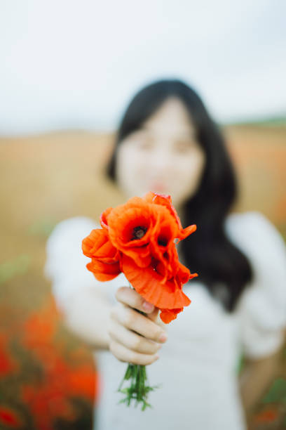 Beautiful Asian woman enjoying the beautiful scene of the poppy field.