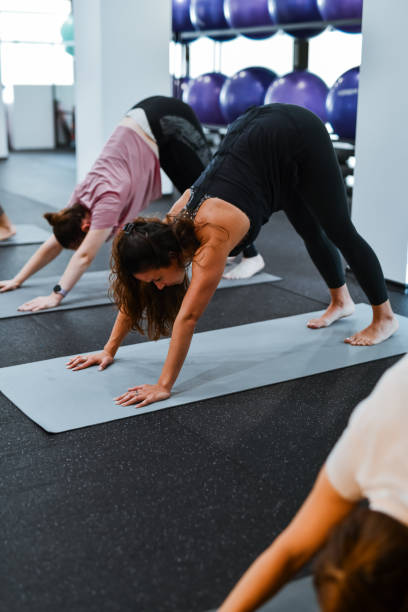 istock Females Stretching Back And Hamstrings Through Downward Facing Dog Position During Yoga Workout 2158701788