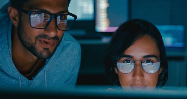 istock Closeup of Tech team professionals collaborate discuss software development strategies late night in modern office. Software developer, artificial intelligence and programming. 2158703079