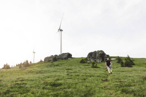 istock Hiking towards wind turbines on a grassy hill 2158703136