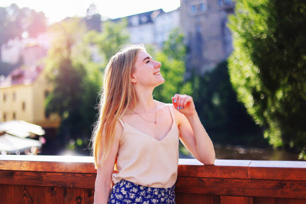 Young woman squinting eyes, as strong sun shines on her