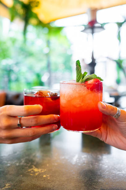 istock Two hands clinking cocktail glasses with a pink beverage 2158704469