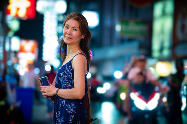 istock Mature Asian Woman Exploring Bangkok's Night Streets 2158704888